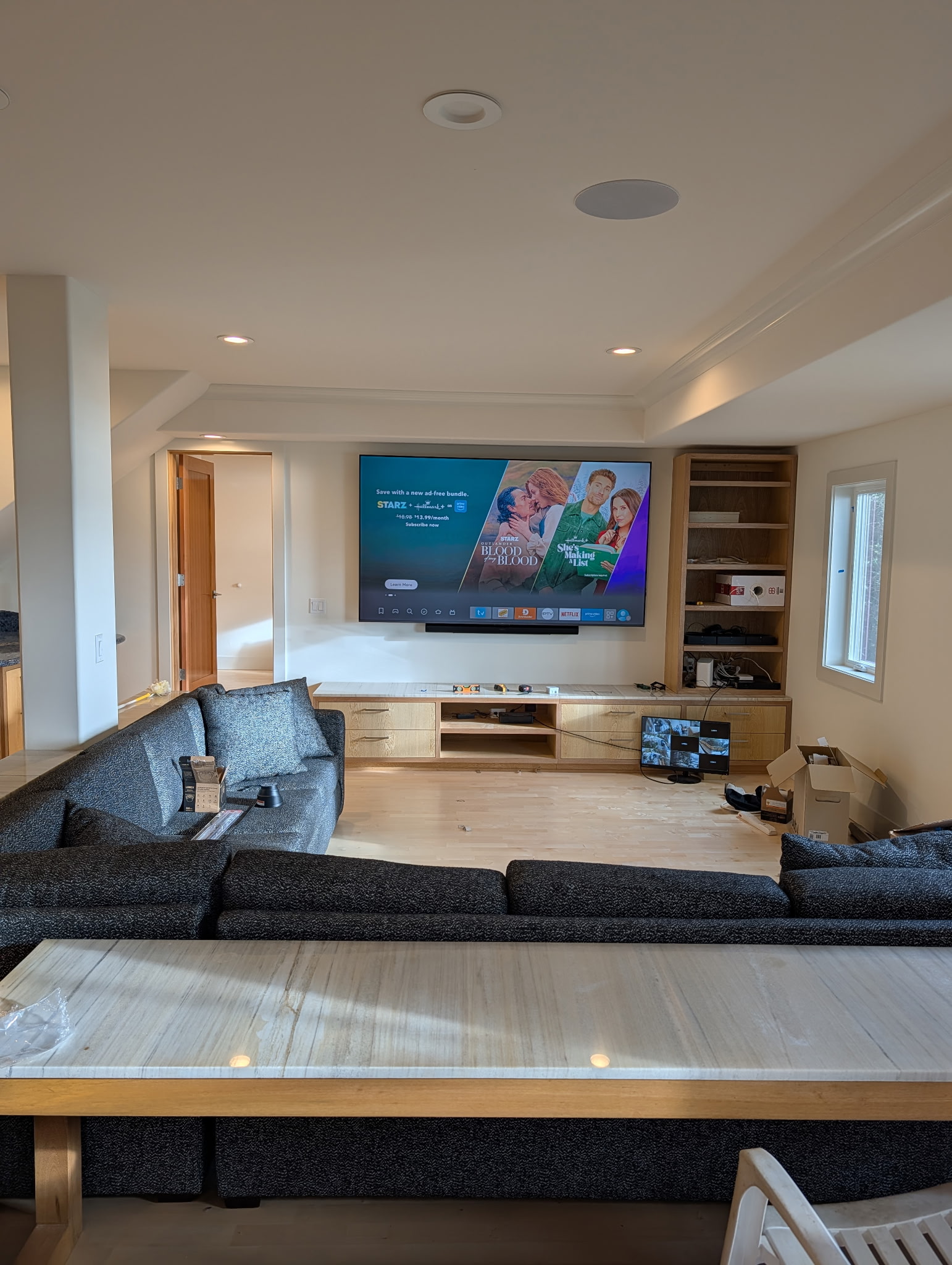 Media room with wall-mounted display and live security camera grid on monitor