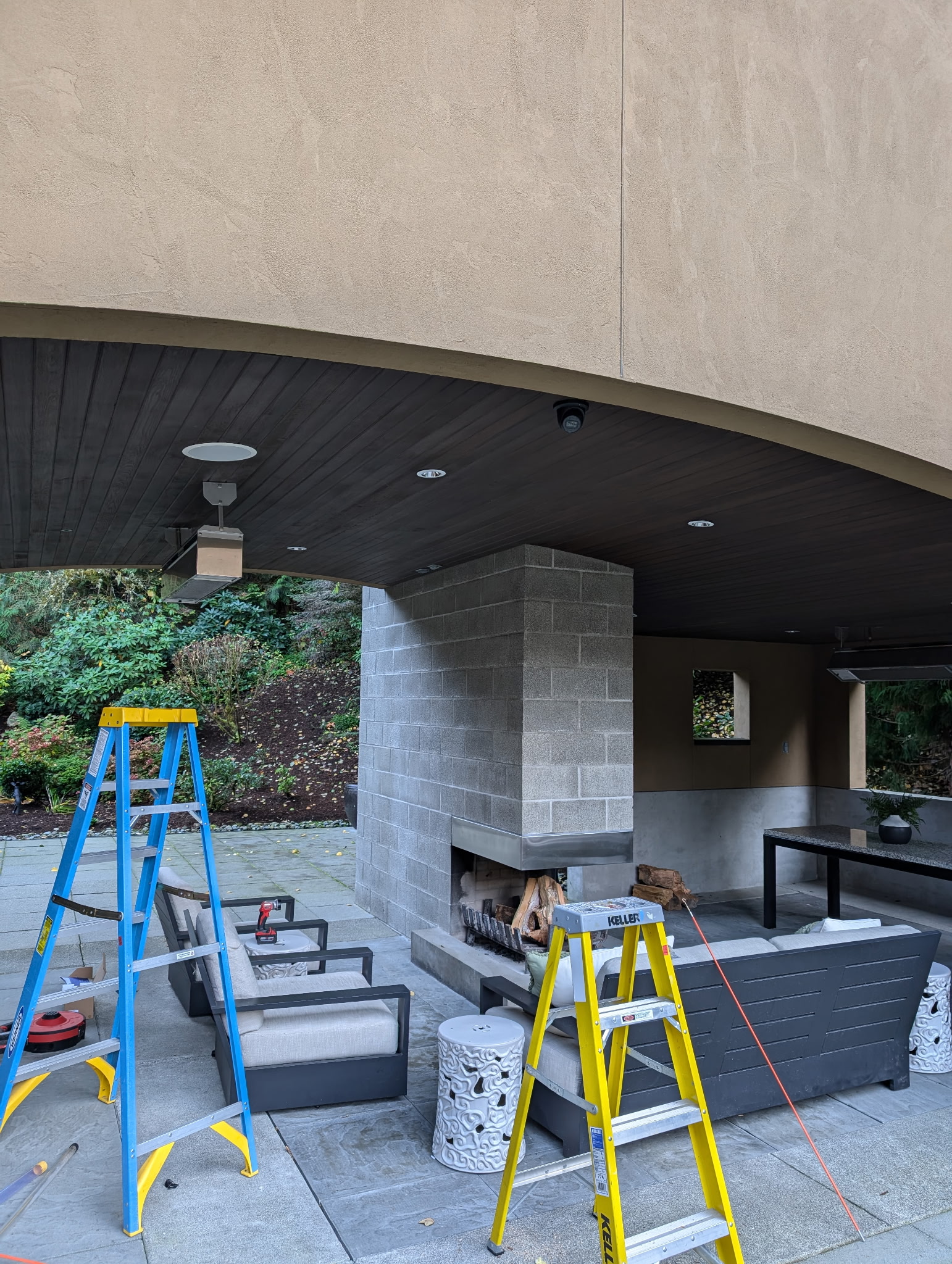 Outdoor living space with discrete dome camera integrated into wood ceiling during professional installation